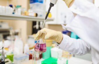 Chemical lab with scientist using a pipette